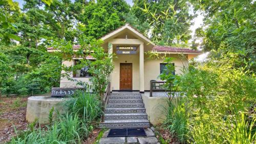 a small house with stairs leading to the front door at Tathastu Kanha in Kānha