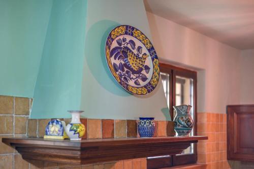 a plate on the wall above a shelf with vases at Agriturimo Cà Dorale in Fano