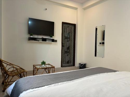 a bedroom with a bed and a flat screen tv on the wall at Mount Valley in Chamba