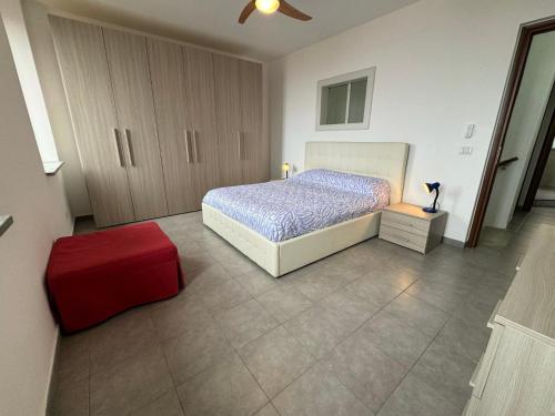 a bedroom with a bed and a red ottoman at Casa Panorama in Motta San Giovanni