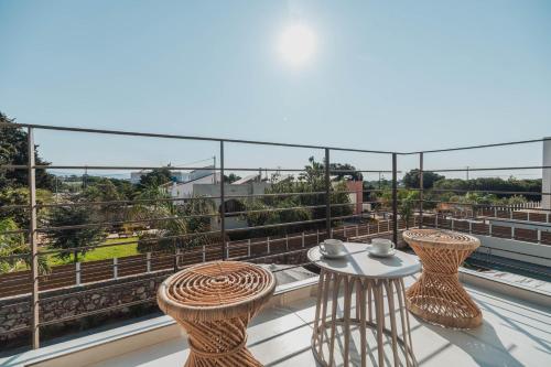 a balcony with two chairs and a table on a roof at Nos Aqua Villas Chania in Pazinos