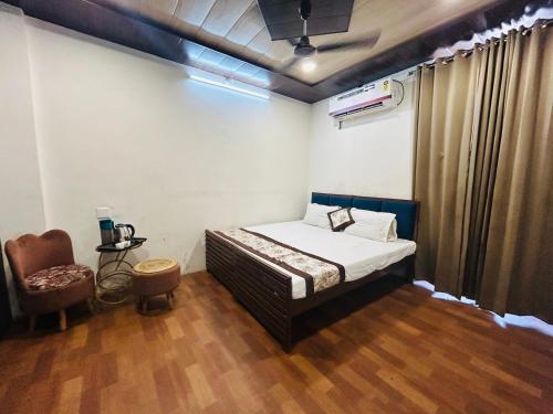 a bedroom with a bed and a chair in it at HOTEL SHIVIKA in Bikaner