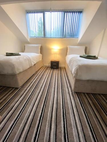 a attic bedroom with two beds and a window at St James Residence close city centre in Killingbeck