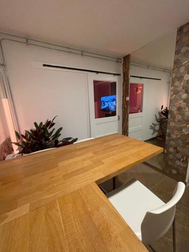a dining room with a wooden table and a white chair at Spartementen by Pure-Zen in Rotterdam