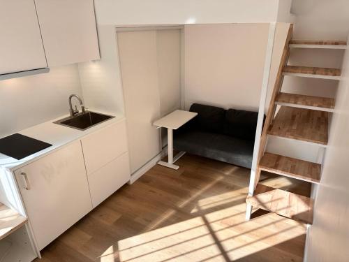 une petite cuisine avec un évier et un canapé dans l'établissement Studio Metro Paris La-defense, à Asnières-sur-Seine