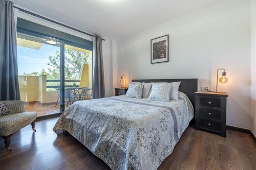 een slaapkamer met een bed en een glazen schuifdeur bij Apartamento Las Joyas in Estepona