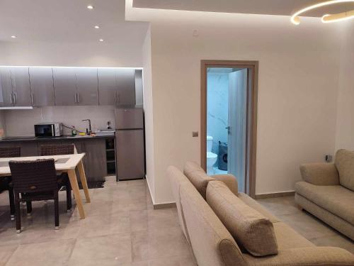 a living room with a couch and a table and a kitchen at Lena Studios in Sidari
