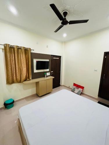 a bedroom with a bed and a ceiling fan at River view paying guest house in Varanasi