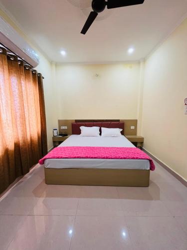 a bedroom with a large bed with pink sheets at River view paying guest house in Varanasi