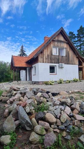 a house with a pile of rocks in front of it at Król Puszczy - unikatowy dom, jezioro 80m, szlak Krutyni in Ruciane-Nida