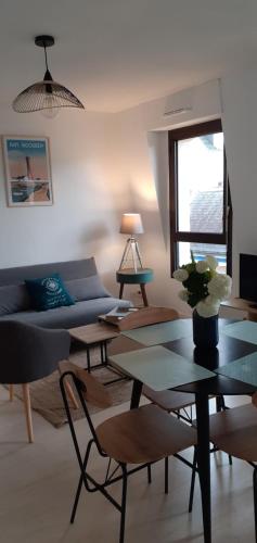 un salon avec un canapé et une table dans l'établissement Appartement terrasse au cœur de Pont l'Abbé, à Pont-lʼAbbé