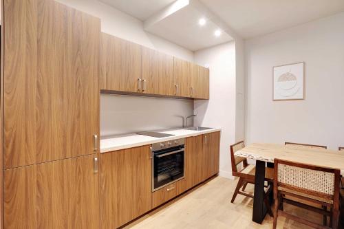 une cuisine avec des armoires en bois et une table en bois dans l'établissement Spacious Apartment - 2BR-10P - Place d'Italie, à Paris