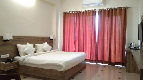a bedroom with a bed and a red curtain at Dhawala Resort By Aamod in Alwar