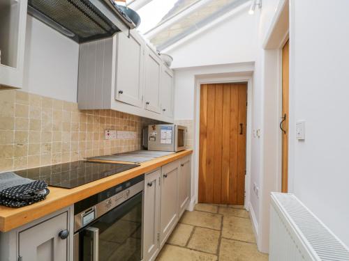 a kitchen with white cabinets and a skylight at The Lodge in Quenington