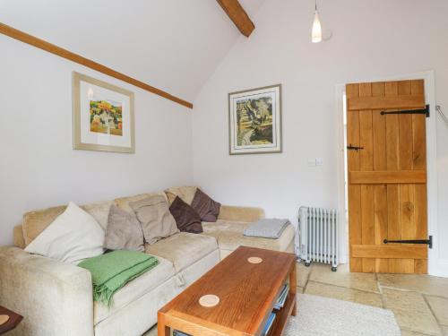 a living room with a couch and a wooden table at The Lodge in Quenington
