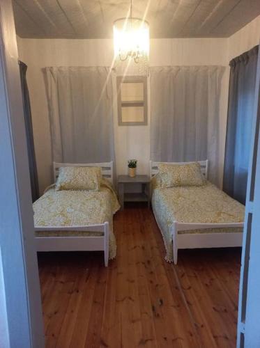 two beds in a room with wooden floors at Eresina in Eresos