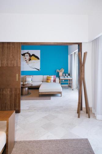 a living room with a white couch and a blue wall at ME Cabo by Meliá in Cabo San Lucas