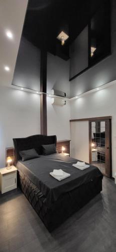 a bedroom with a large black bed in a room at Bumerang Apartmans, New Belgrade, Belgrade Arena in Belgrade