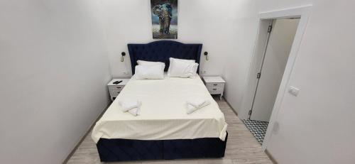 a small bedroom with a bed with a blue headboard at Bumerang Apartmans, New Belgrade, Belgrade Arena in Belgrade