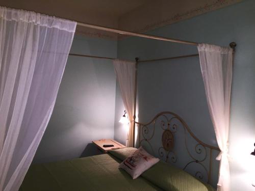 a bedroom with a canopy bed with white curtains at B&B 8380 Saturnia Terme in Saturnia