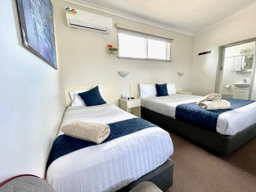 a hotel room with two beds and a window at The Highlander Motel - 24HR Check In in Maryborough