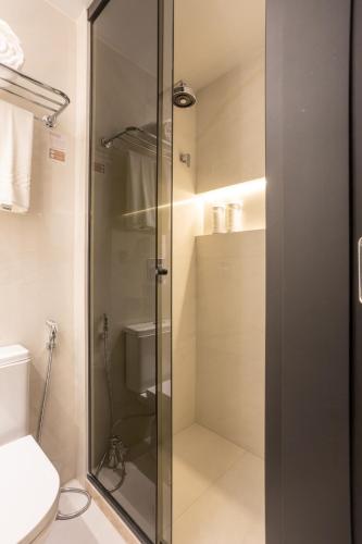 a glass shower in a bathroom with a toilet at Icon Hotel by Welkom in João Pessoa