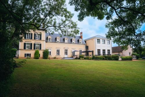 une grande maison avec une grande pelouse devant elle dans l'établissement Domaine de la Tremblère, à Arthon