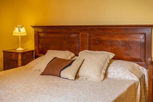 a bed with a wooden headboard and two pillows at Agriturimo Cà Dorale in Fano