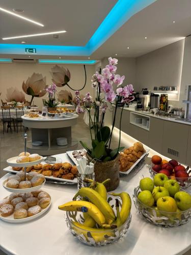 a buffet of food on a table with bananas and other fruits at Albergo Pesce D'oro in Verbania