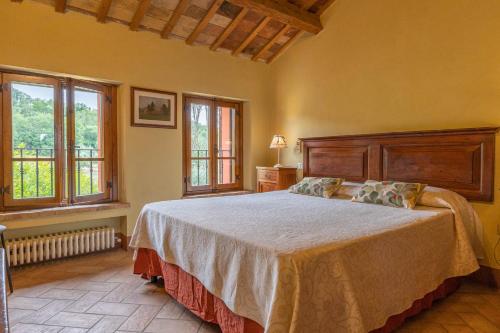 a bedroom with a large bed and two windows at Agriturimo Cà Dorale in Fano