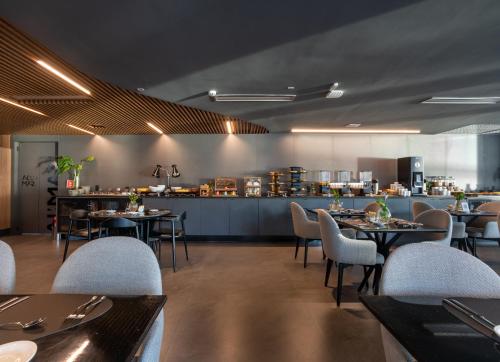 a restaurant with tables and chairs and a bar at Icon Hotel by Welkom in João Pessoa