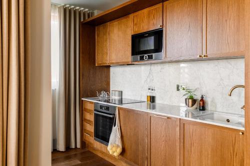 a kitchen with wooden cabinets and a stove top oven at Luxury Apartments in a vibrant part of North London in London