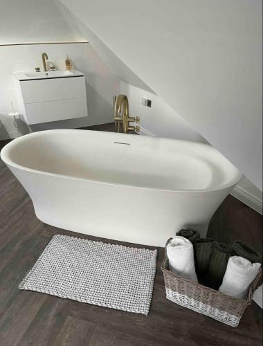 a white bath tub in a bathroom with a sink at Branksome house Worcester in Worcester