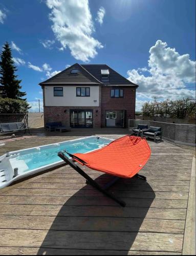 a hammock sitting on a deck next to a pool at Branksome house Worcester in Worcester