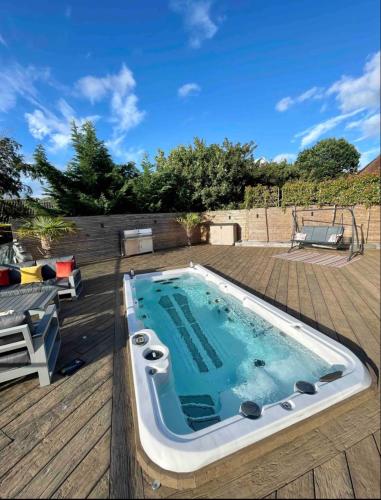 a large swimming pool on a deck with a wooden deck at Branksome house Worcester in Worcester