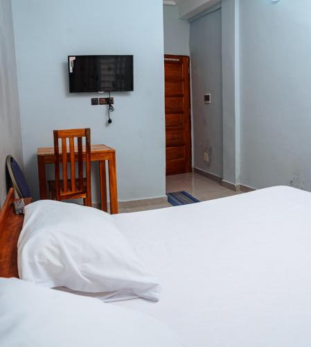 Postel nebo postele na pokoji v ubytování Hôtel Merveille Lomé