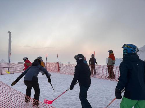 a group of people are playing in the snow at Porthos Ski-in Lodge with private hot tub and sauna in Lapland in Pyhätunturi