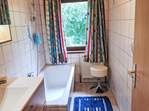 a bathroom with a tub and a sink and a window at Apartment Eleonore by Interhome in Litzlberg
