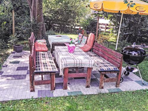 a picnic table and two chairs and a grill at Apartment Eleonore by Interhome in Litzlberg