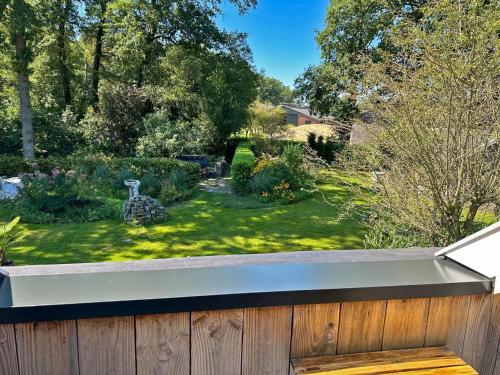 a backyard with a wooden fence and a garden at 't Klompenhuuske in Rossum