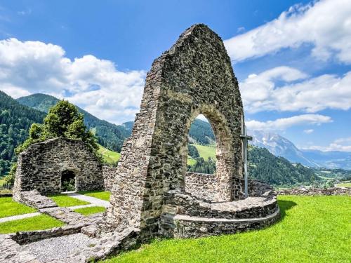 an old stone building on a hill with mountains in the background at Apartment Mölbegg by Interhome in Donnersbach