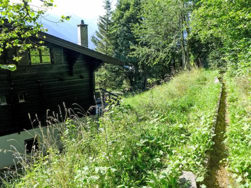 a house on the side of a hill next to a field at Chalet Sans Nom by Interhome in Mollens