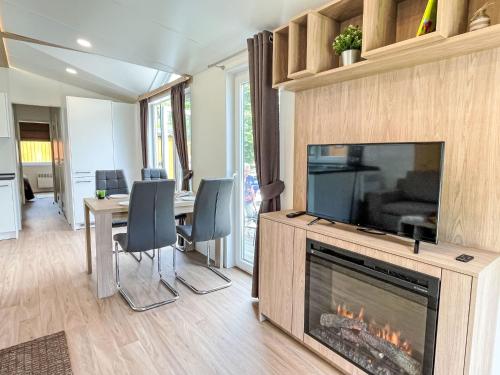 リーデンブルクにあるHoliday Home Tiny Haus Suite Altmühlperle by Interhomeのリビングルーム(暖炉、テーブル、椅子付)