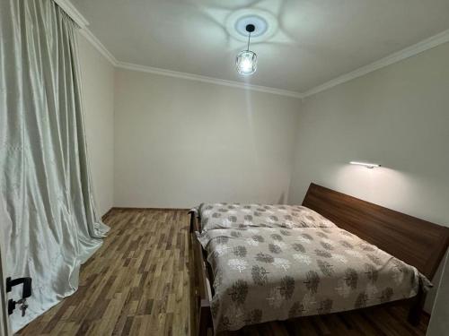 a small bedroom with a bed and a window at House in the Bamboos in Batumi