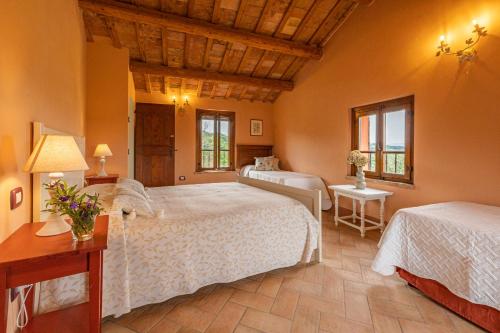 a bedroom with two beds and a table with a lamp at Agriturimo Cà Dorale in Fano