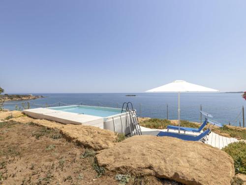 a swimming pool with the ocean in the background at Holiday Home Norbert by Interhome in Siracusa