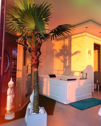 a bathroom with a palm tree and a bath tub at Sea Side Calais vue mer in Calais