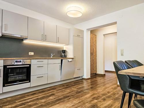 a kitchen with white cabinets and a table and chairs at Apartment Inn by Interhome in See