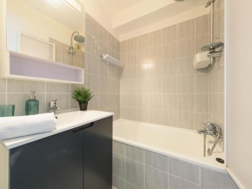 une salle de bain avec une baignoire et un lavabo dans l'établissement Apartment Les Floralies II-14 by Interhome, au Grau-du-Roi