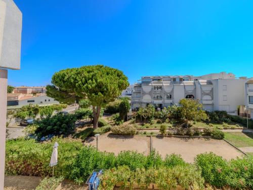 - une vue sur le jardin en face d'un bâtiment dans l'établissement Apartment Les Floralies II-14 by Interhome, au Grau-du-Roi